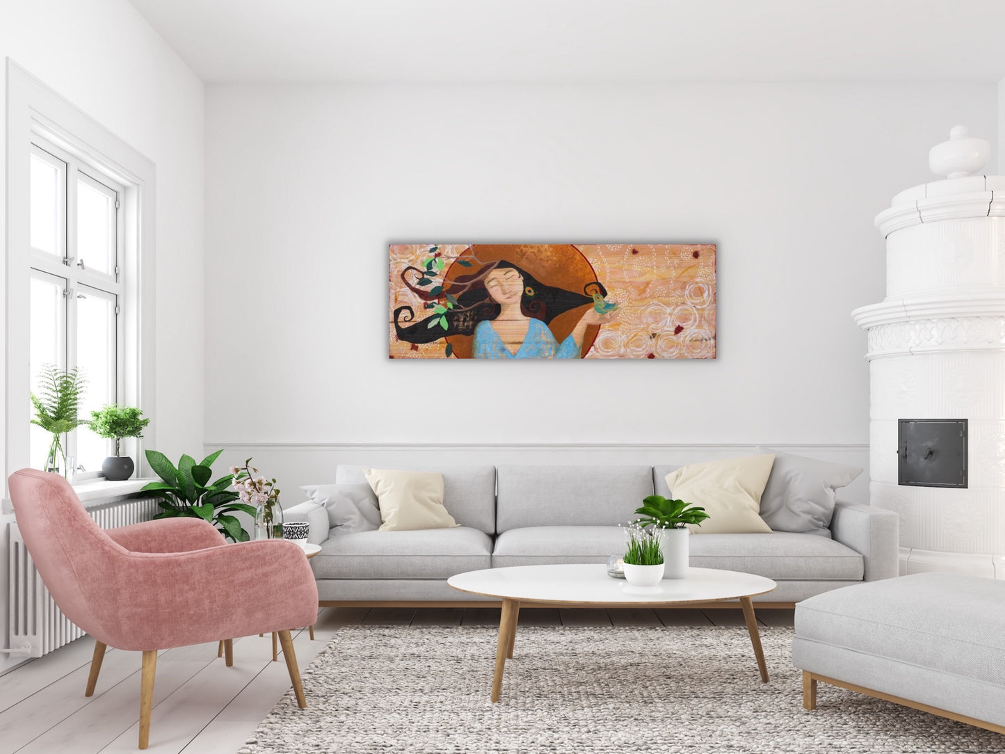 large mixed media painting on wood depicting a beautiful woman holding a bird in her hand. The painting is on the wall of a living room with white furniture, a pink chair and green plants
