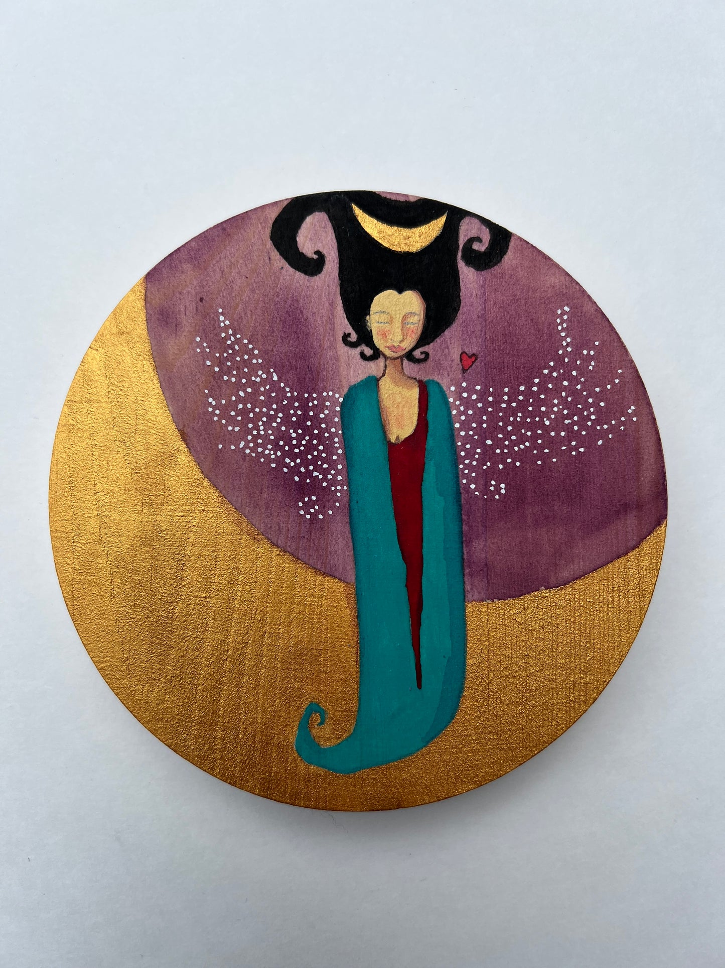 A painting of a woman with an amorphic body draped in teal and red. She has black curly hair with a crescent moon in it. She has white-dotted wings. She hovers above a golden crescent moon.  The background is purple with a tiny red heart above her wing.