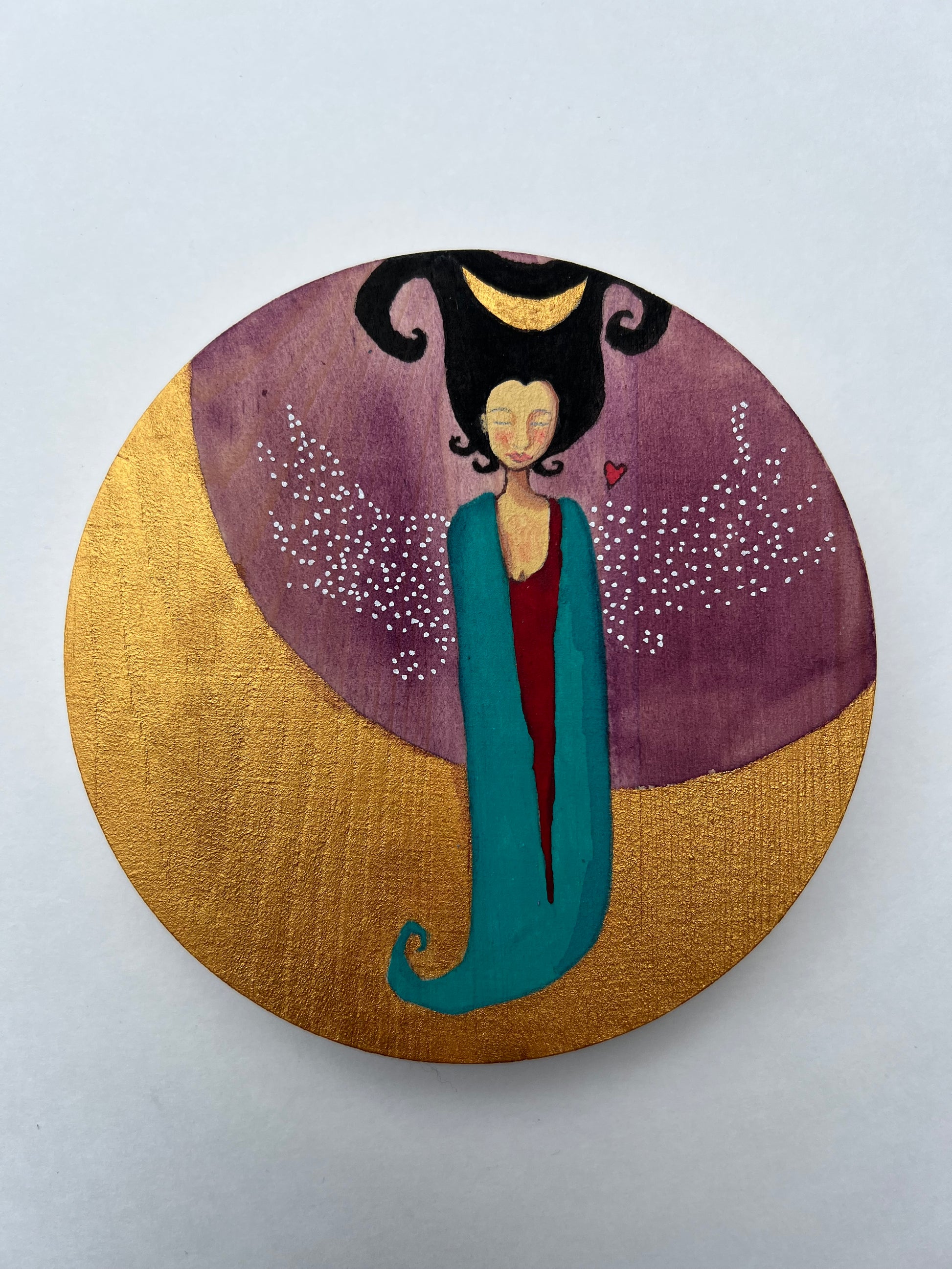 A painting of a woman with an amorphic body draped in teal and red. She has black curly hair with a crescent moon in it. She has white-dotted wings. She hovers above a golden crescent moon.  The background is purple with a tiny red heart above her wing.