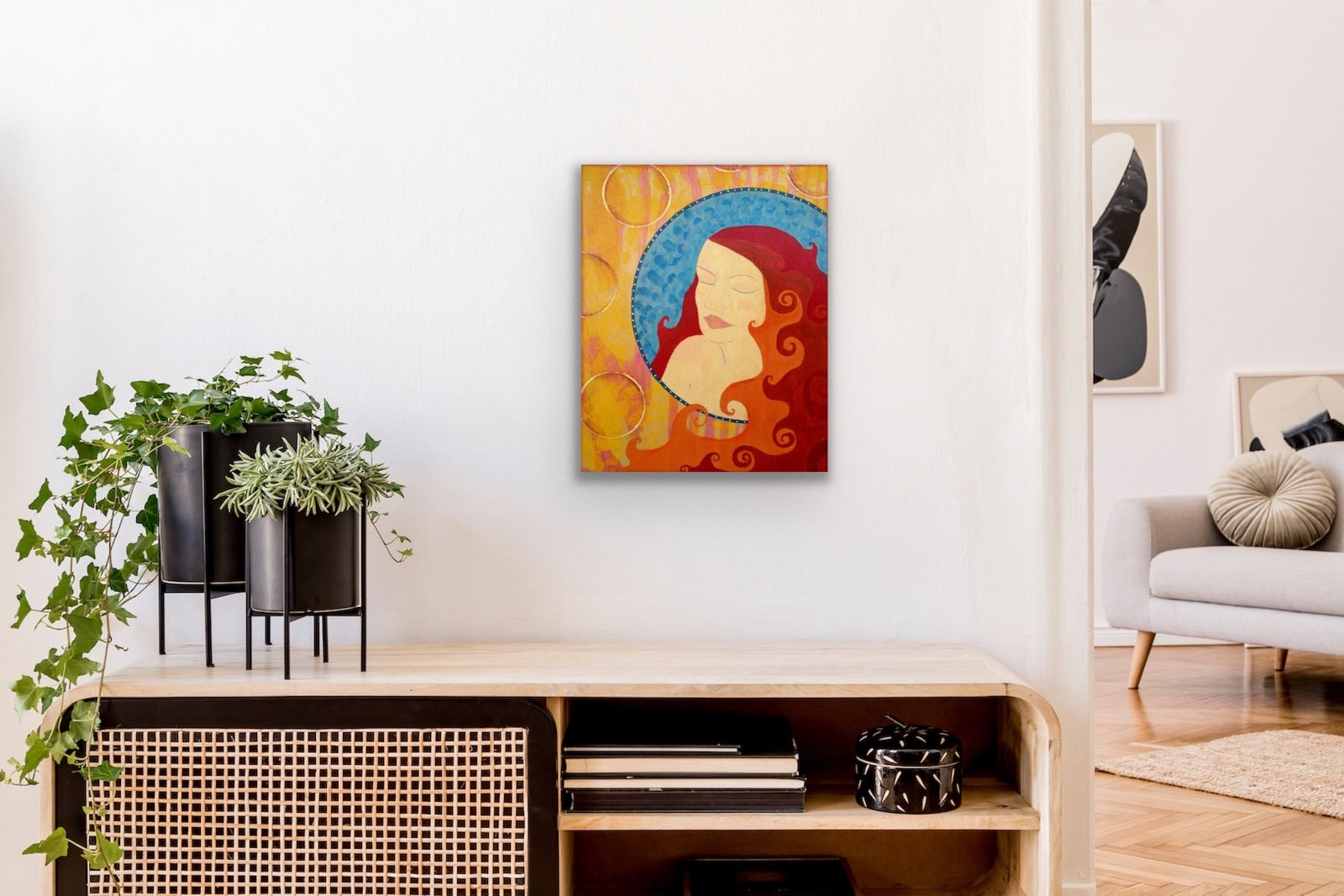 bright colorful stylized portrait of a woman hanging on a white wall above a shelving unit with plants. 